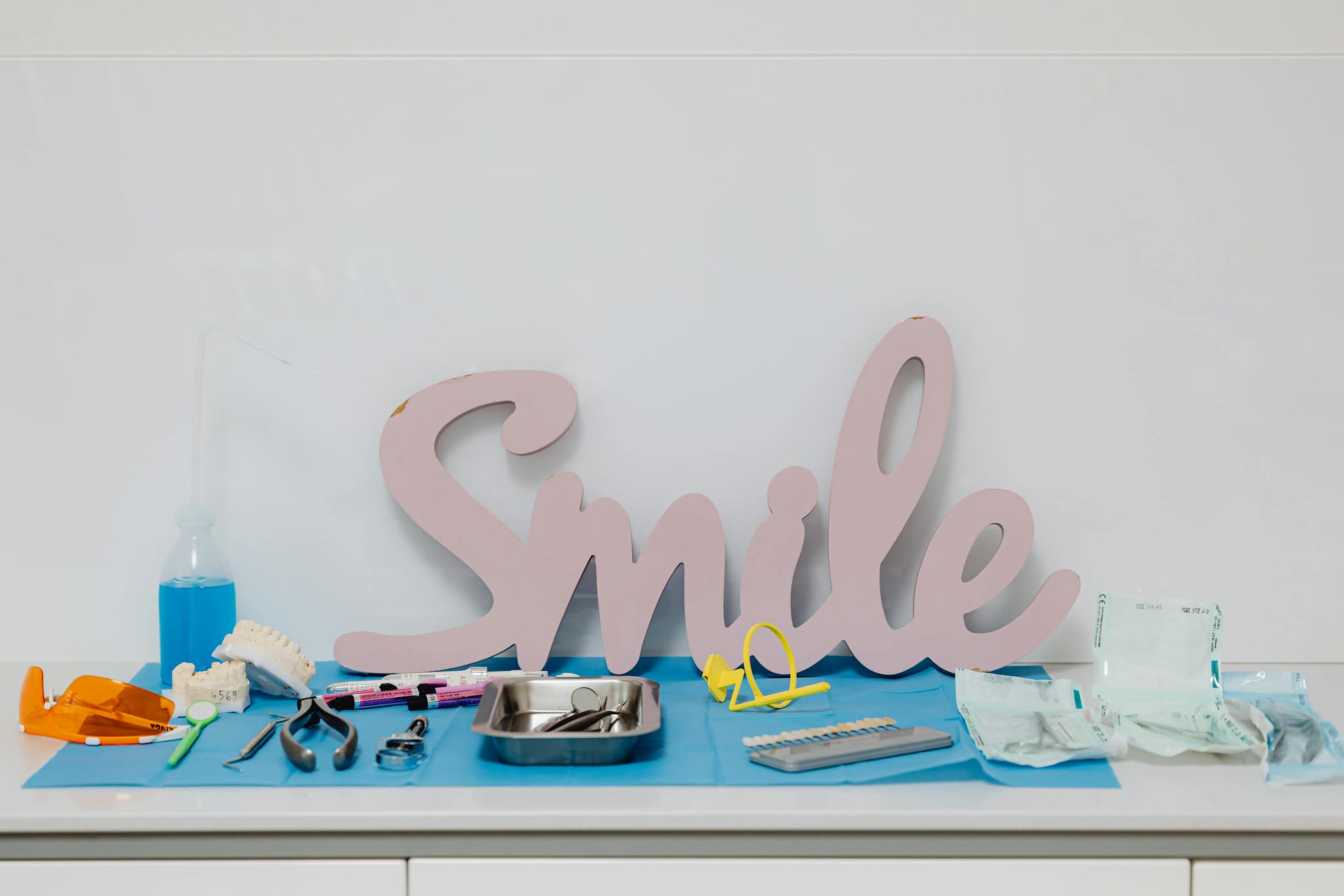 A collection of dental tools and a smile sign on a hygienic surface, ideal for healthcare concepts.