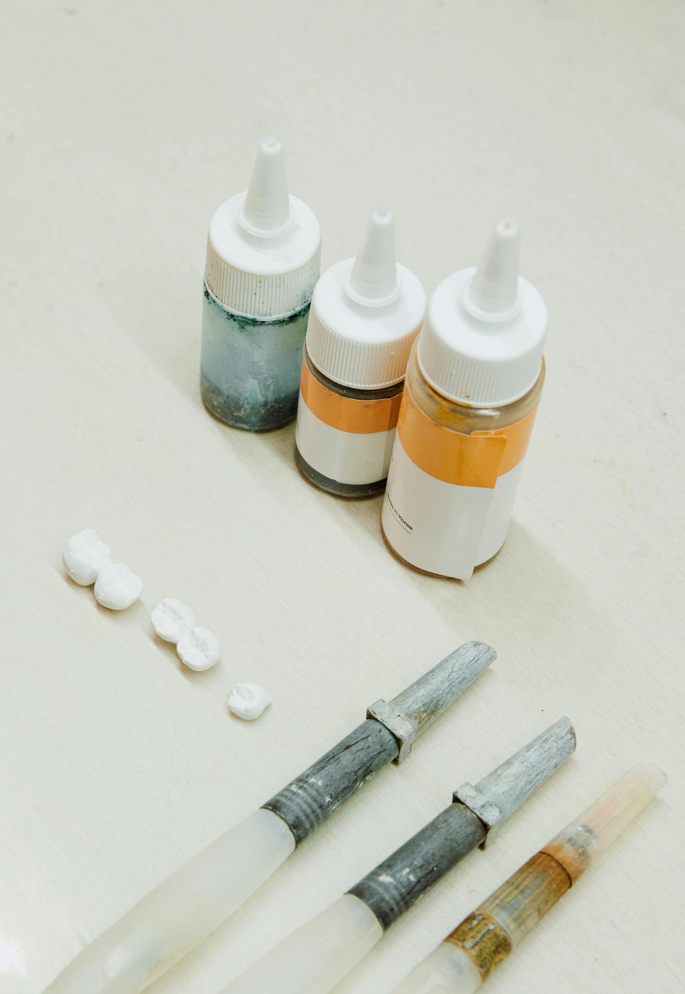 A high-angle view of dental laboratory tools and materials on a clean white surface.